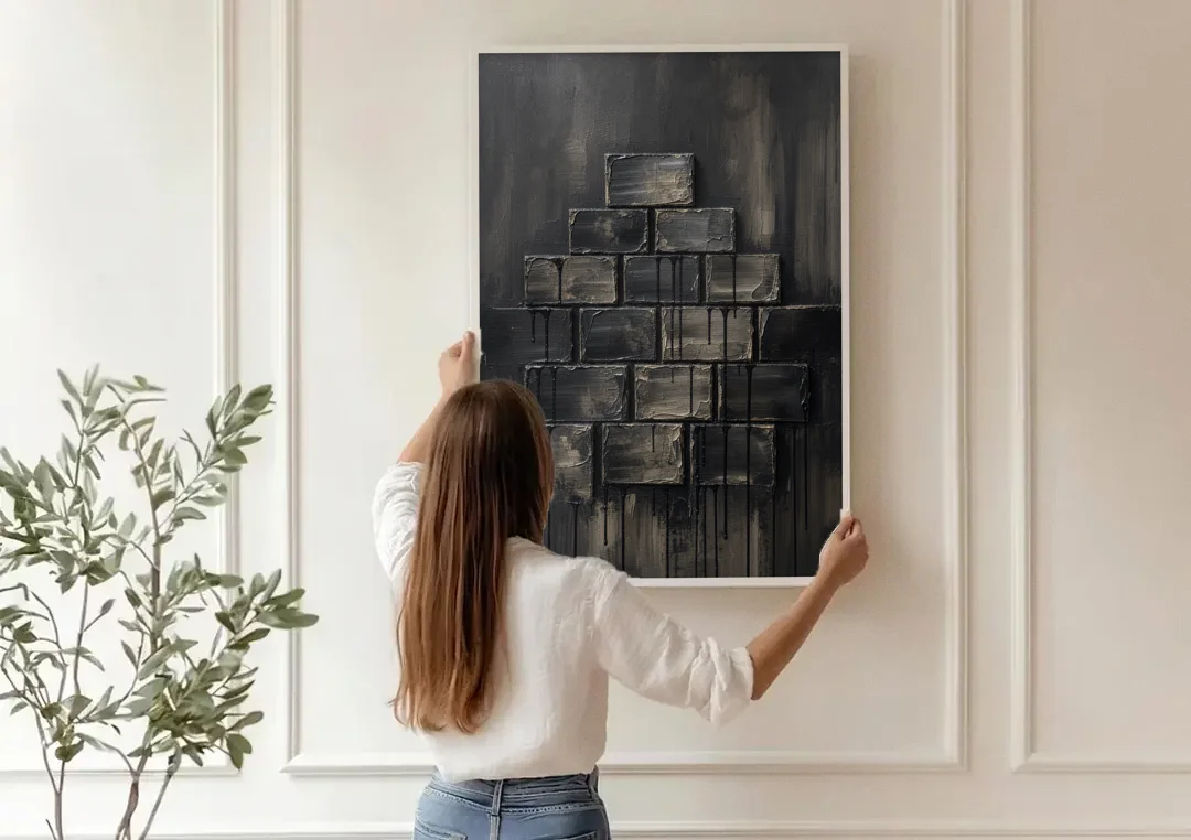 Relief Wall Art of Stacked Charcoal Blocks canvas wall art being hung on a paneled wall