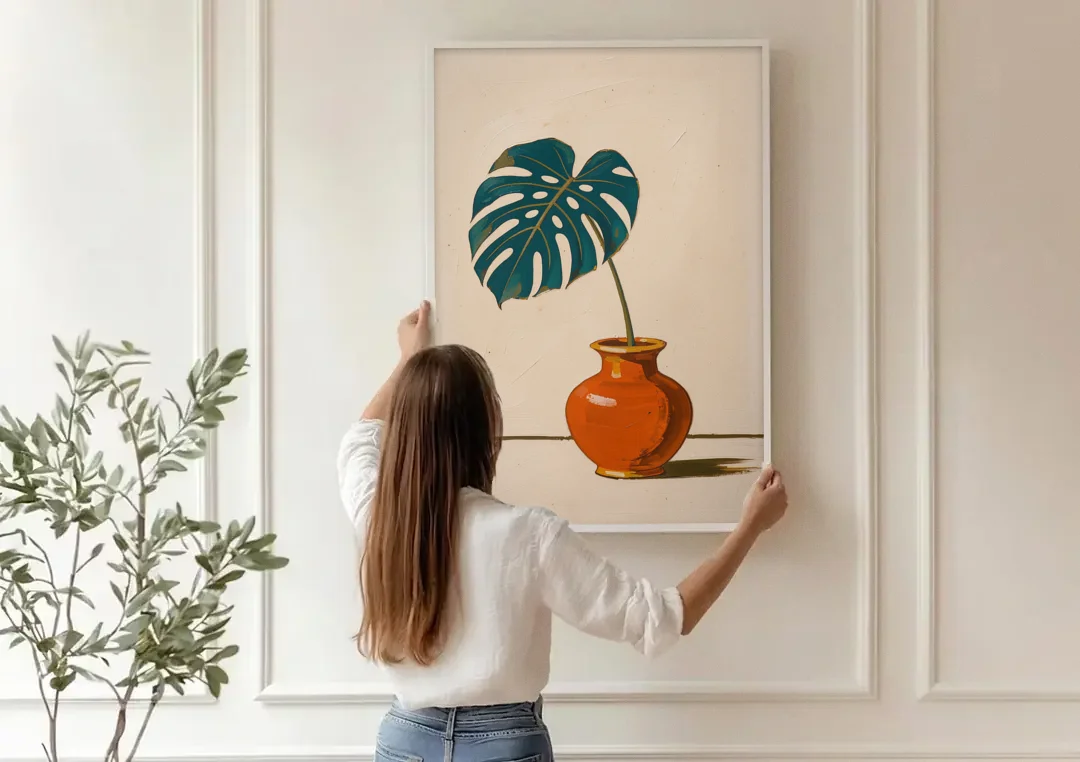 Retro Botanical Prints Monstera Leaf in a Clay Vase canvas wall art being hung on a paneled wall