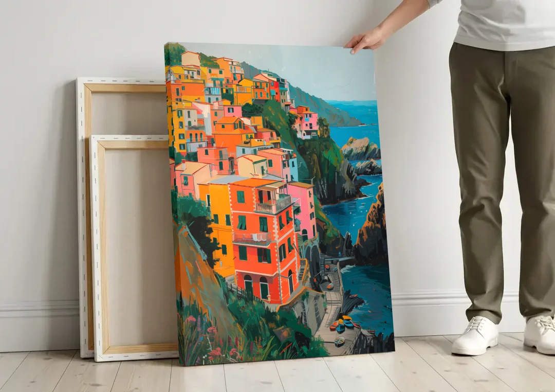 Riomaggiore Painting Above the Sea canvas wall art leaning against a wall next to blank canvases