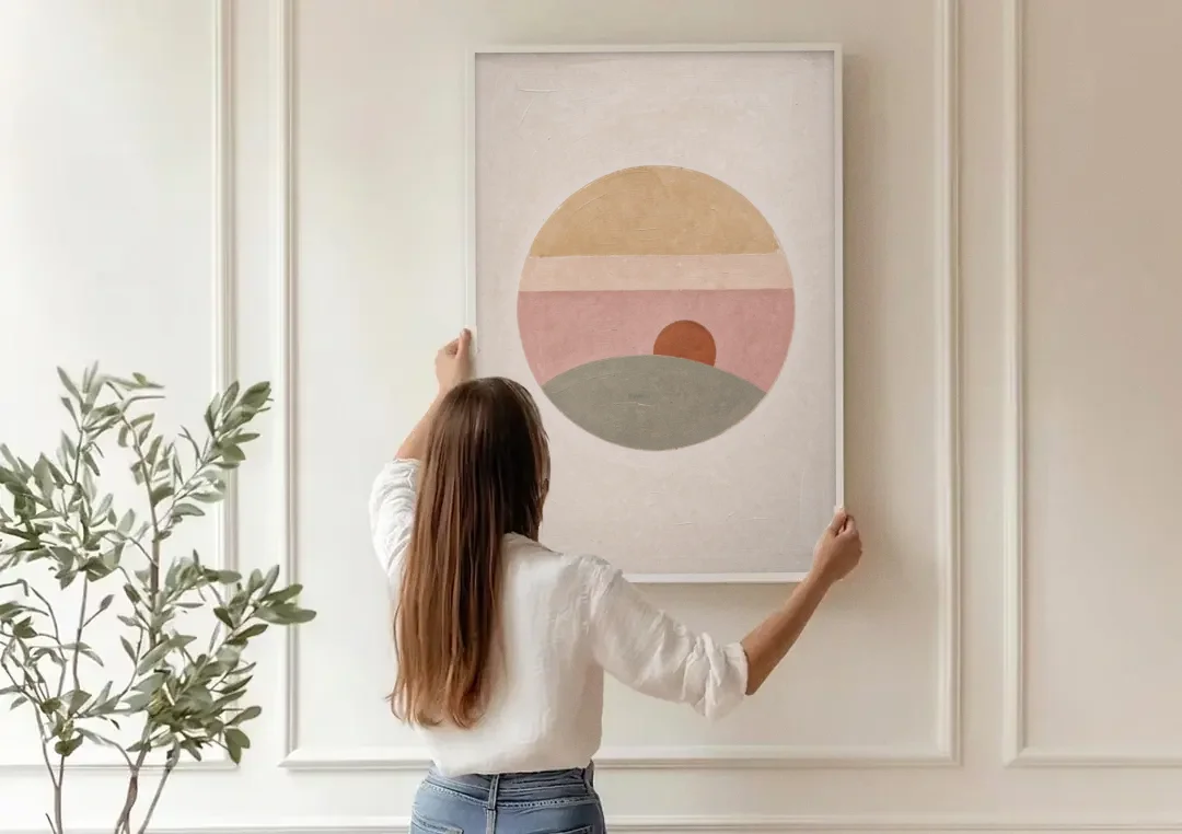 Round Window Landscape with Low Rust Sun canvas wall art being hung on a paneled wall