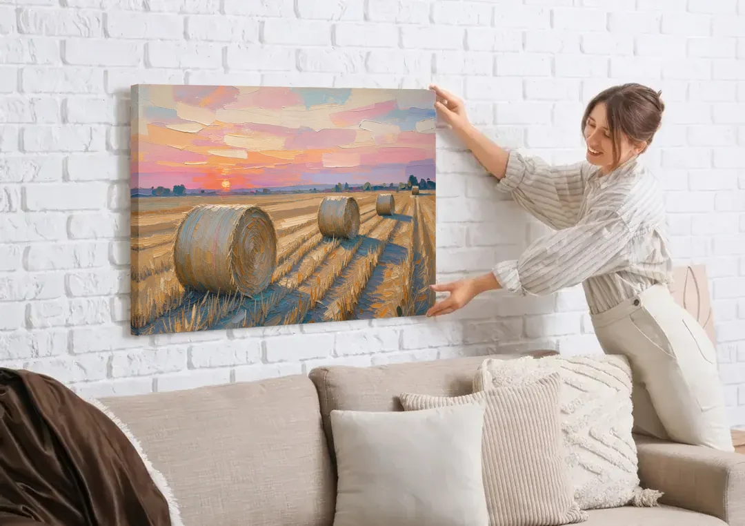 Rural Landscape Painting of Hay Bales at Sunset canvas wall art being hung on a white brick wall above a sofa
