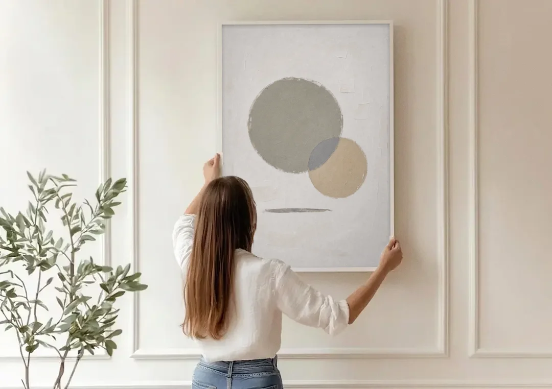 Sage Green Abstract Art with a Dry Grass Circle canvas wall art being hung on a paneled wall