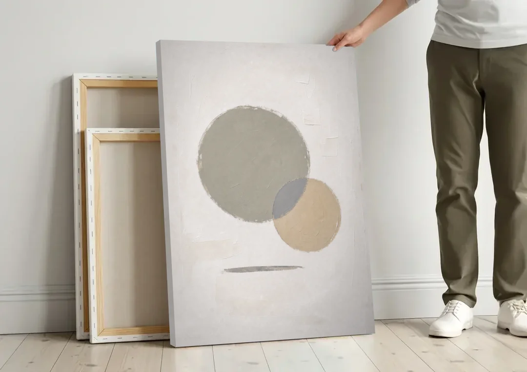 Sage Green Abstract Art with a Dry Grass Circle canvas wall art leaning against a wall next to blank canvases
