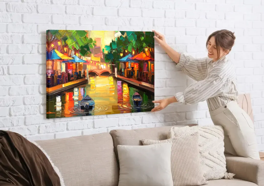 San Antonio Riverwalk Charm canvas wall art being hung on a white brick wall above a sofa