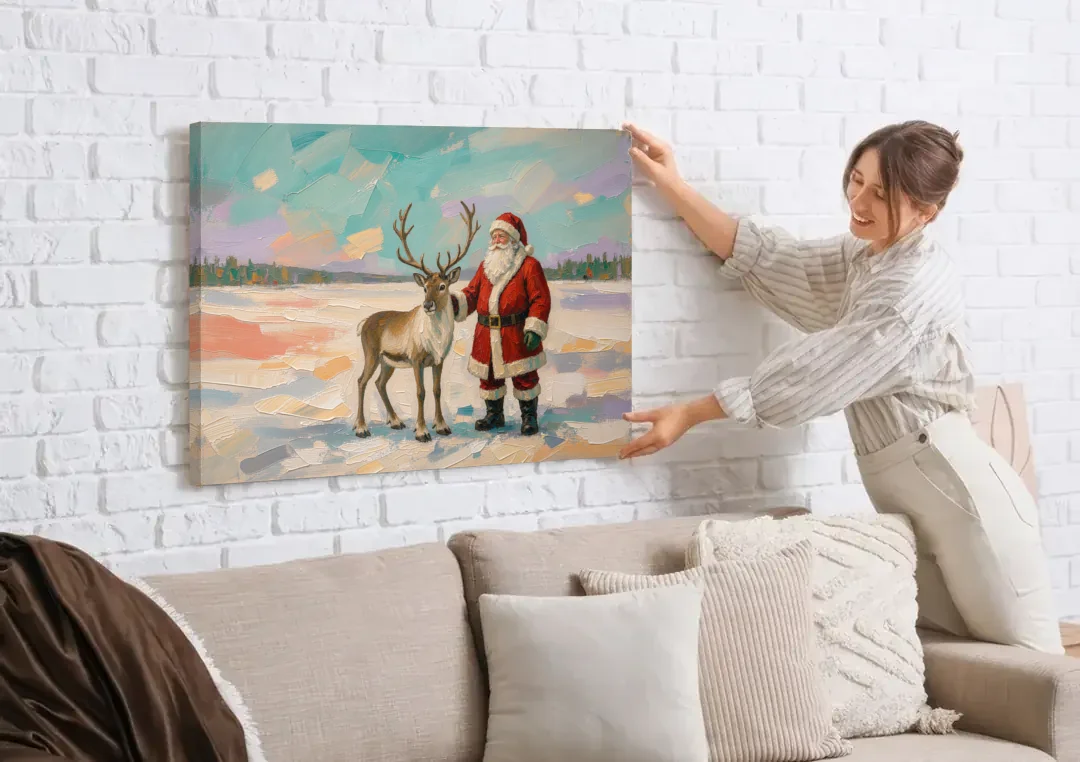 Santa and Reindeer Painting on the Open Snow canvas wall art being hung on a white brick wall above a sofa