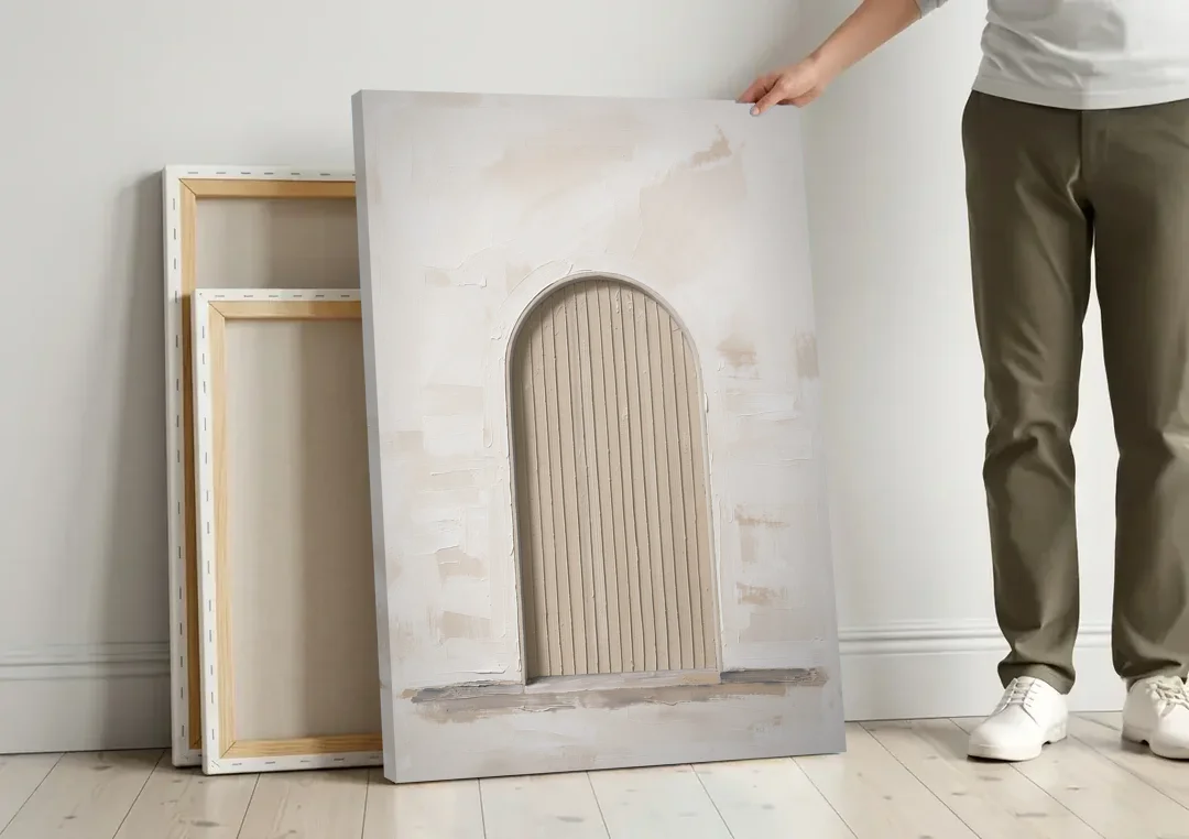 Scandinavian Wall Art Ribbed Beige Arch on Plinth canvas wall art leaning against a wall next to blank canvases