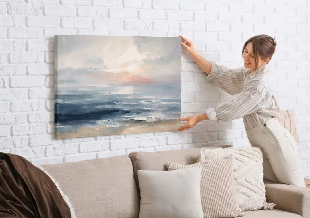 Seascape Painting of a Misty Dawn Horizon canvas wall art being hung on a white brick wall above a sofa