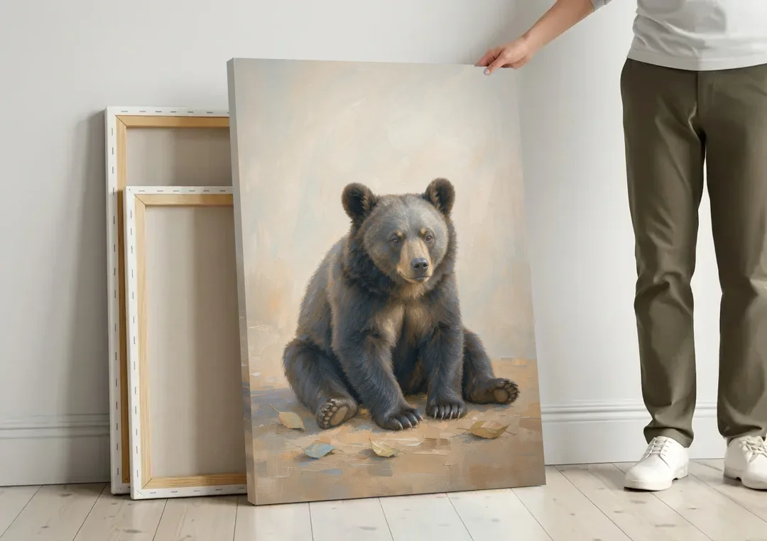 Seated Bear Cub with Fallen Leaves for the Nursery canvas wall art leaning against a wall next to blank canvases