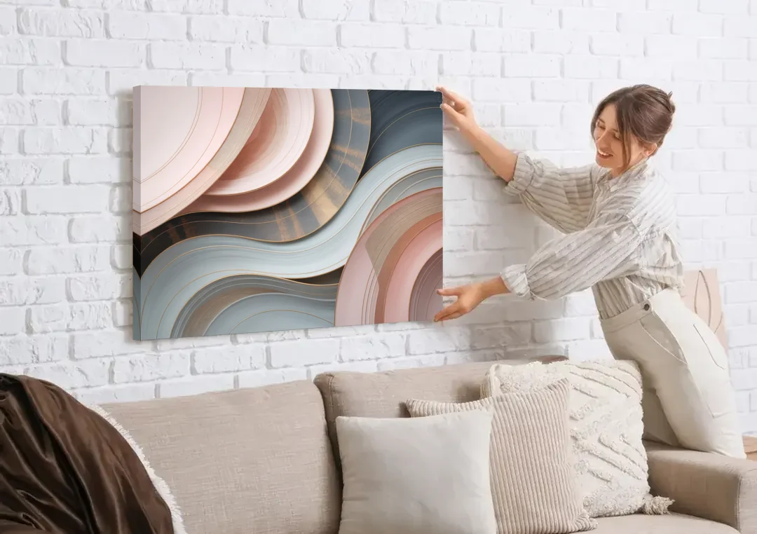Serene Elegance Pink and Grey Abstract canvas wall art being hung on a white brick wall above a sofa