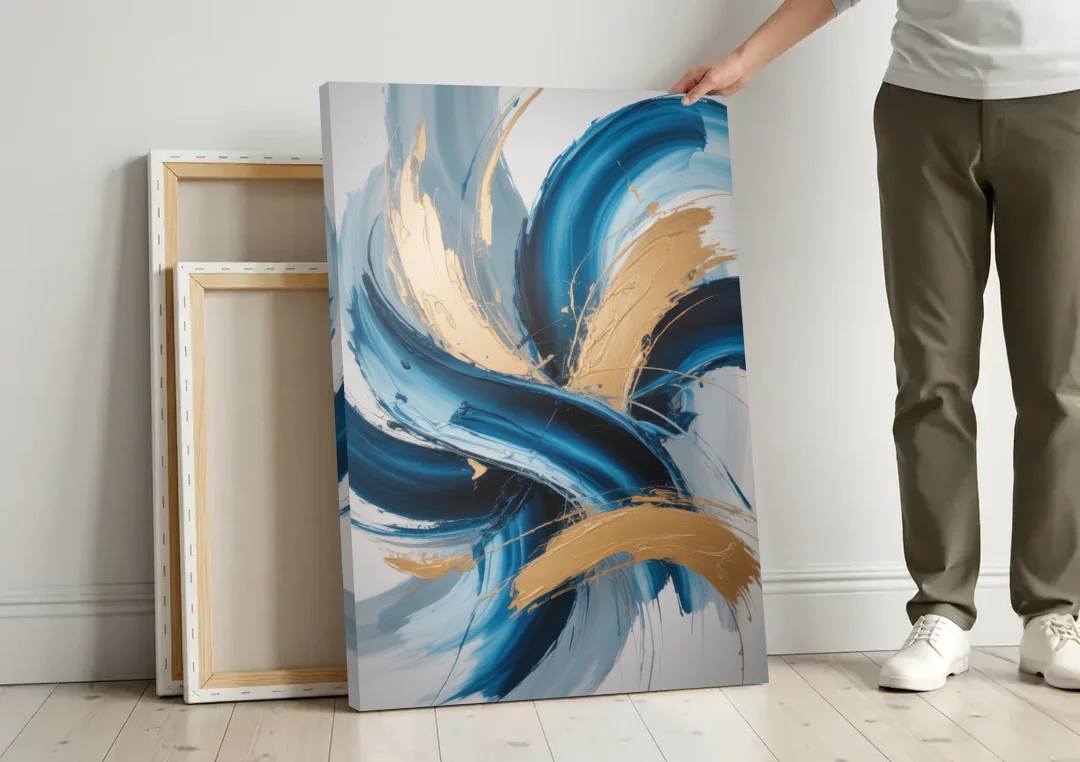 Serene Opulence Blue and Gold Abstract canvas wall art leaning against a wall next to blank canvases