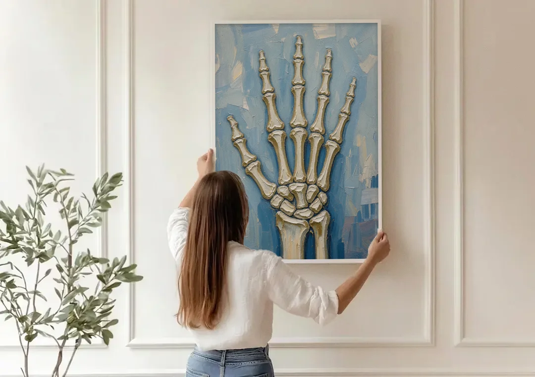 Skeleton Hand Painting Spread Wide Open canvas wall art being hung on a paneled wall
