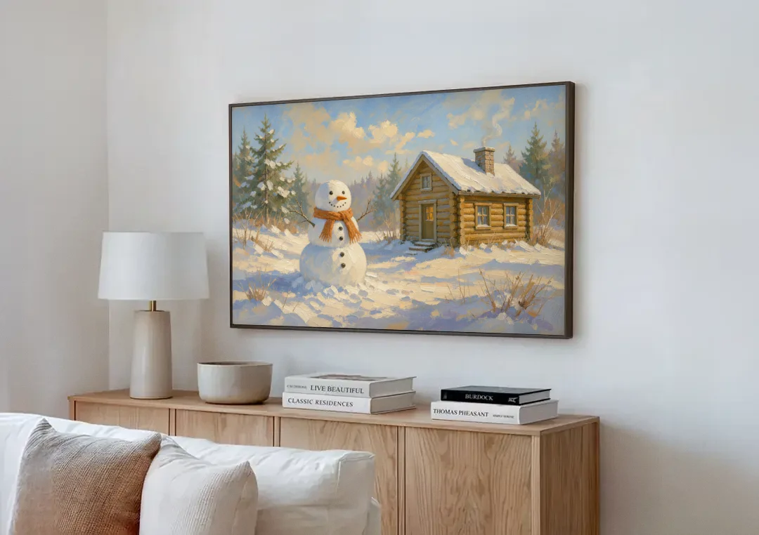 Snowman at the Log Cabin with Chimney Smoke canvas wall art above a wooden sideboard next to a sofa