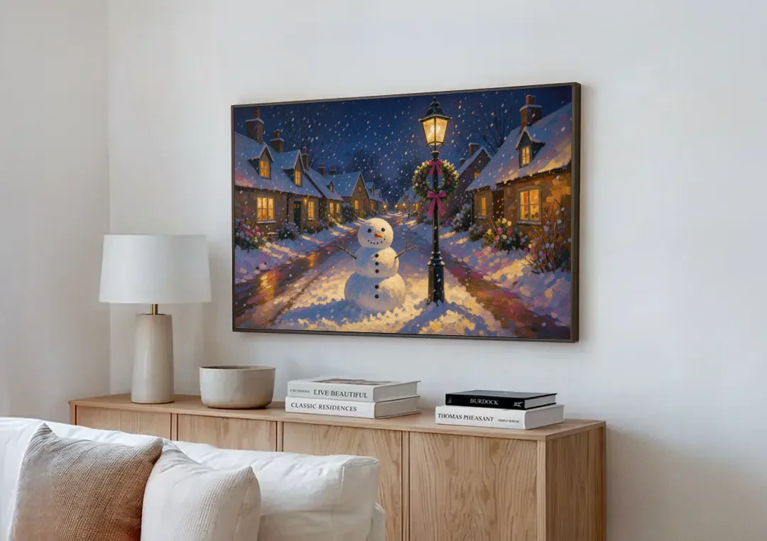 Snowman by the Wreathed Village Lamppost canvas wall art above a wooden sideboard next to a sofa