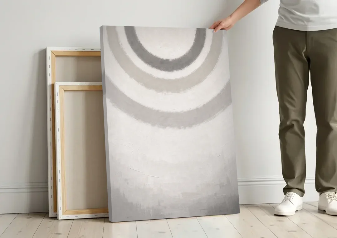 Soft Abstract Painting of Three Grey Ripples canvas wall art leaning against a wall next to blank canvases