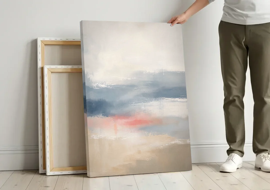 Soft Horizon Bands with a Blush Stroke canvas wall art leaning against a wall next to blank canvases