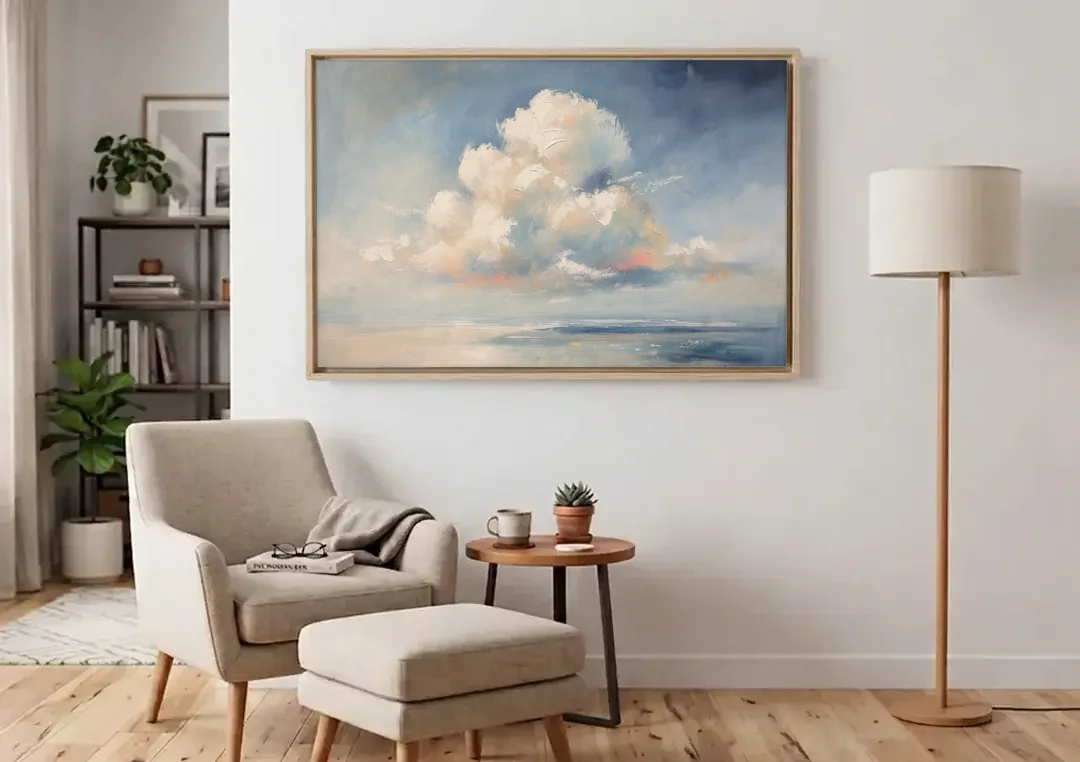 Soft Sky Painting with a Towering Cloud canvas wall art above an armchair in a bright living room