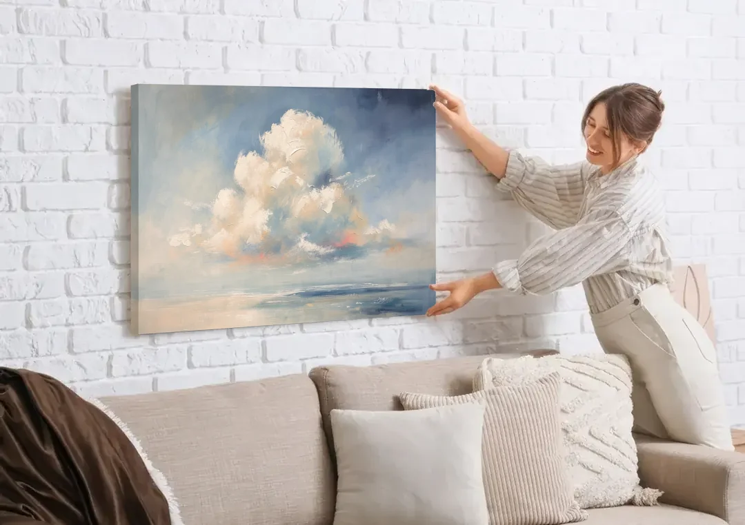 Soft Sky Painting with a Towering Cloud canvas wall art being hung on a white brick wall above a sofa