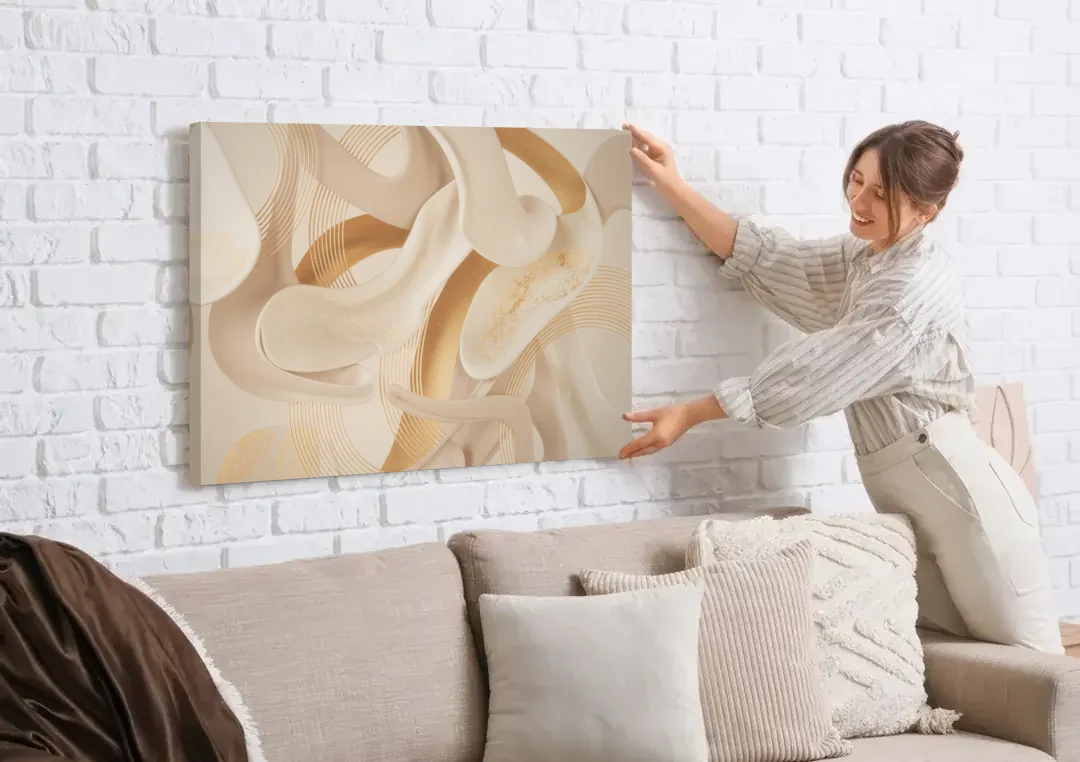 Sophisticated Fluidity Beige Abstract canvas wall art being hung on a white brick wall above a sofa
