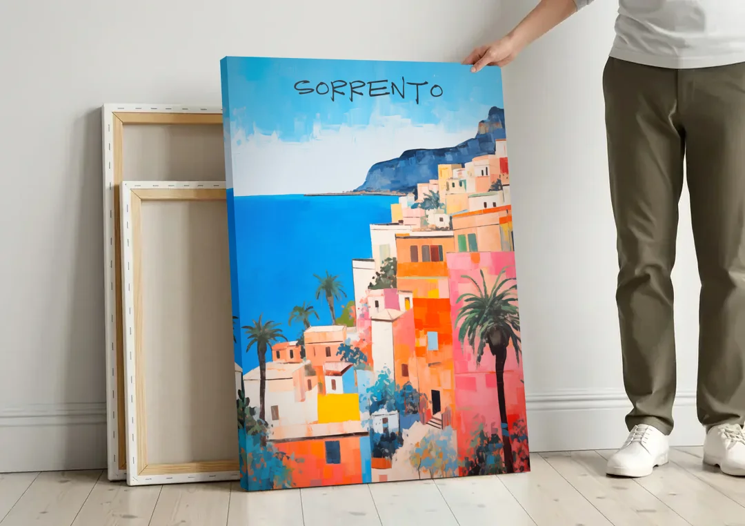 Sorrento Painting of Seaside Houses canvas wall art leaning against a wall next to blank canvases