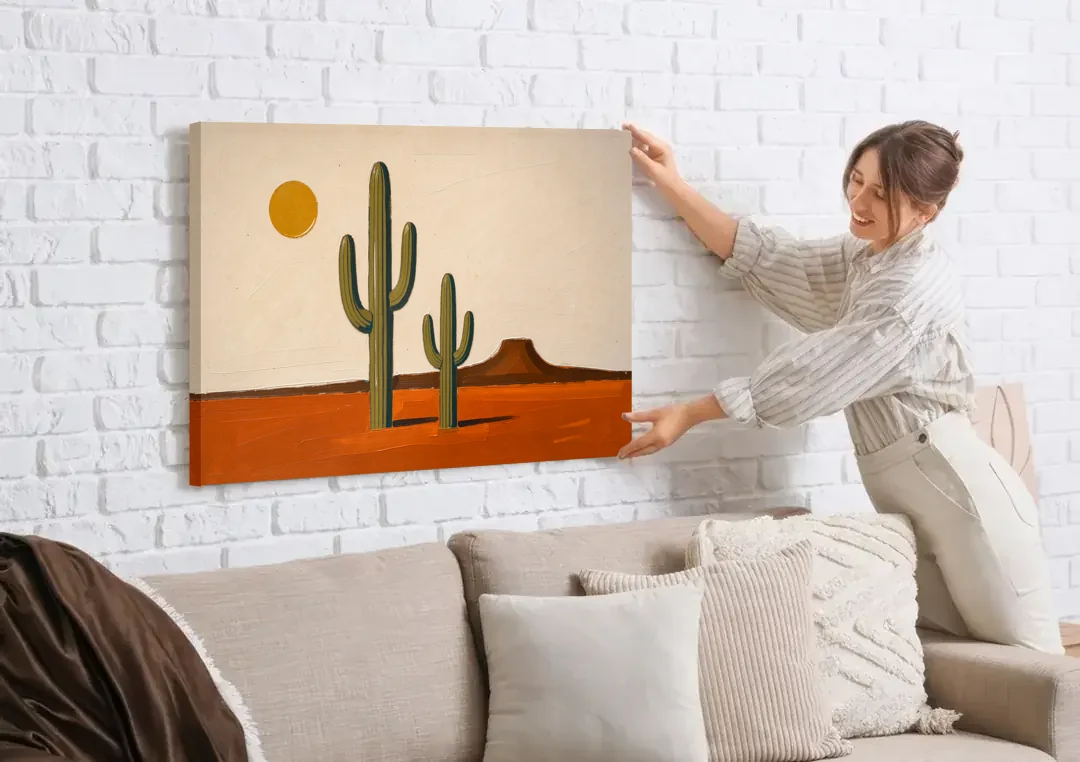 Southwest Wall Art with Two Saguaros Under the Sun canvas wall art being hung on a white brick wall above a sofa