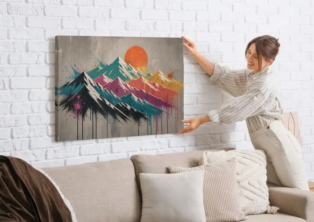 Street Art Spray Stencil Mountain Range Under Orange Sun canvas wall art being hung on a white brick wall above a sofa