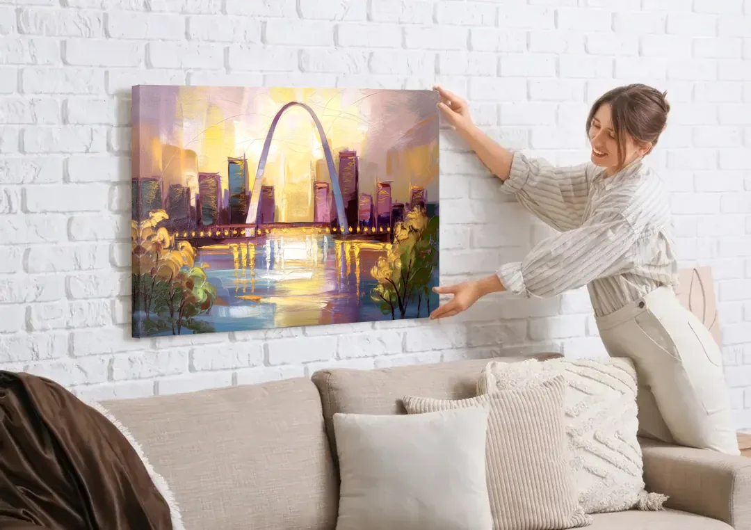 St. Louis Gateway Arch And City Lights canvas wall art being hung on a white brick wall above a sofa