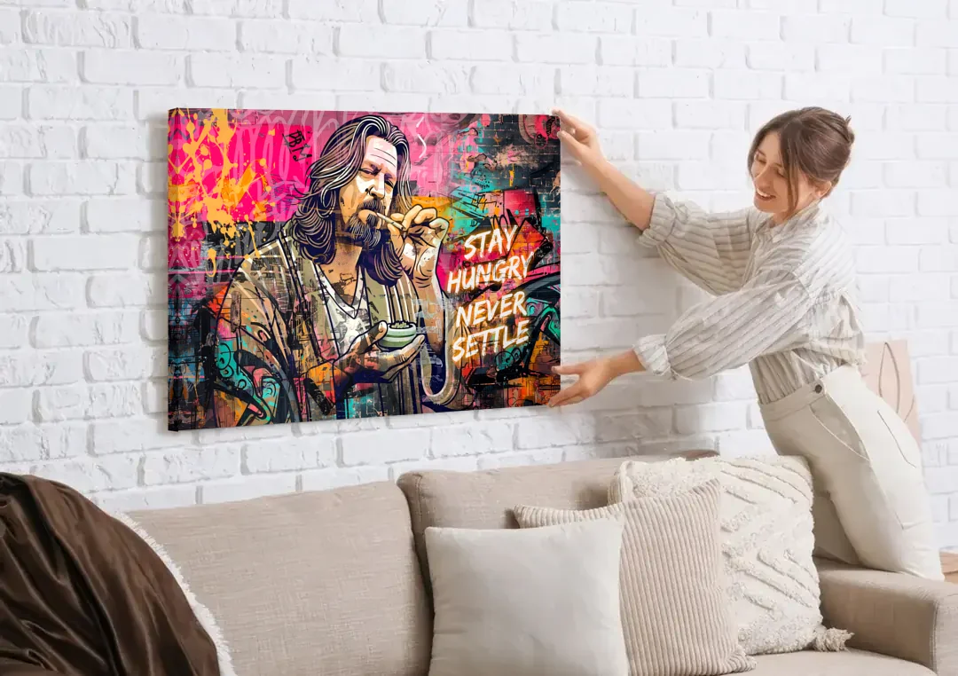 Stay Hungry Never Settle canvas wall art being hung on a white brick wall above a sofa