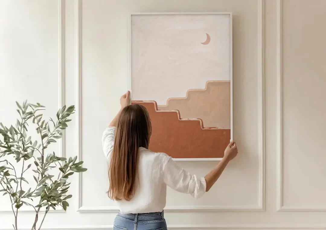 Stepped Adobe Wall Under a Crescent Moon canvas wall art being hung on a paneled wall