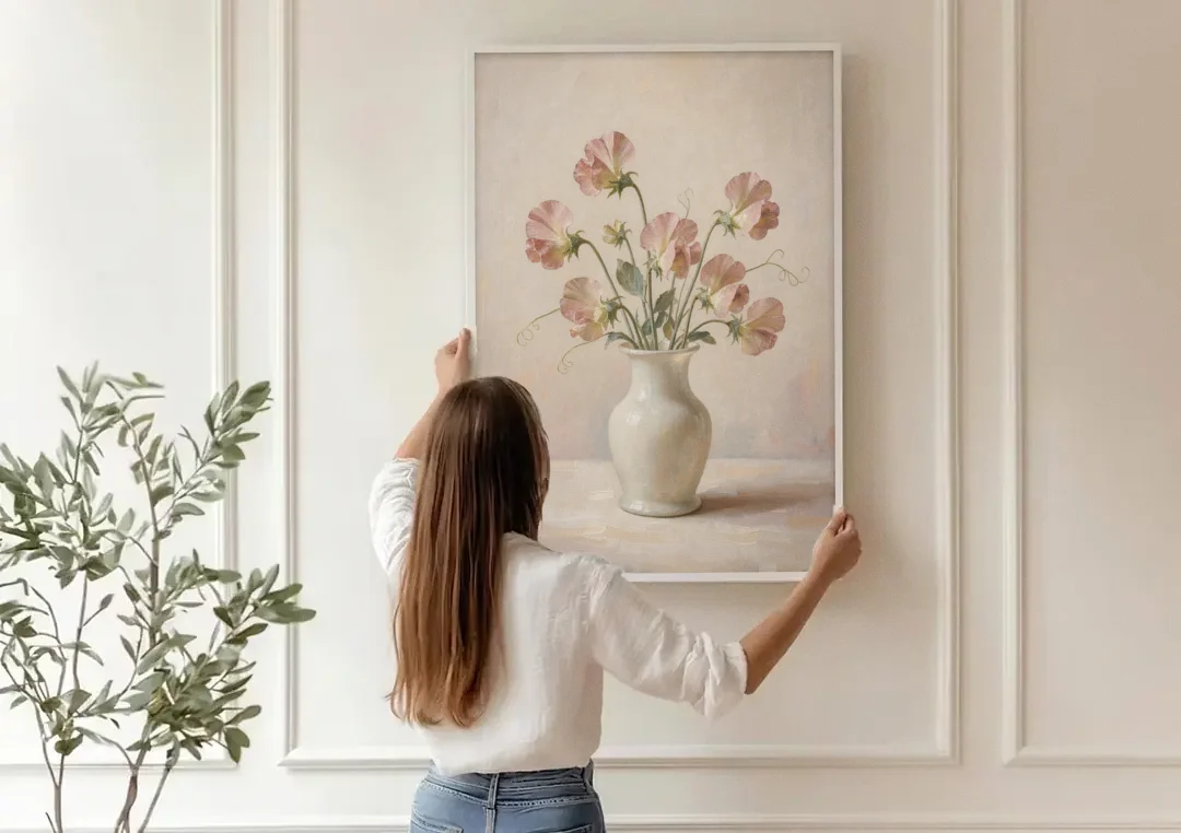 Sweet Peas in an Ivory Milk Glass Vase canvas wall art being hung on a paneled wall