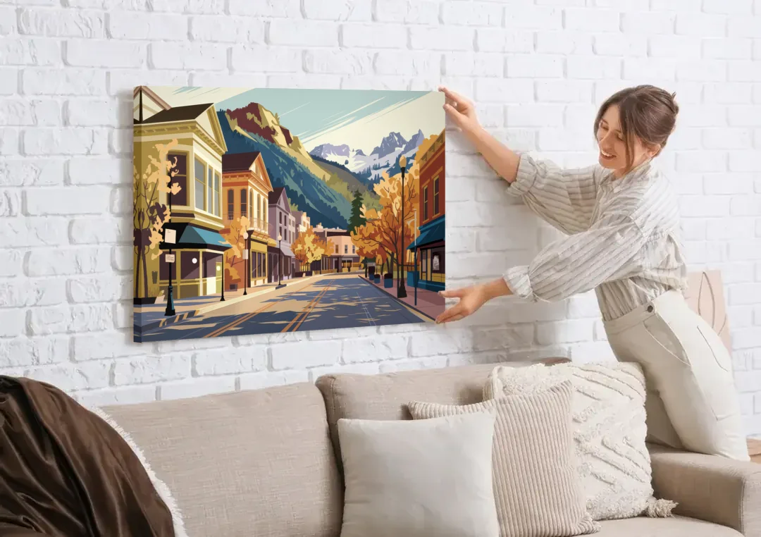 Telluride Historic Main Street canvas wall art being hung on a white brick wall above a sofa