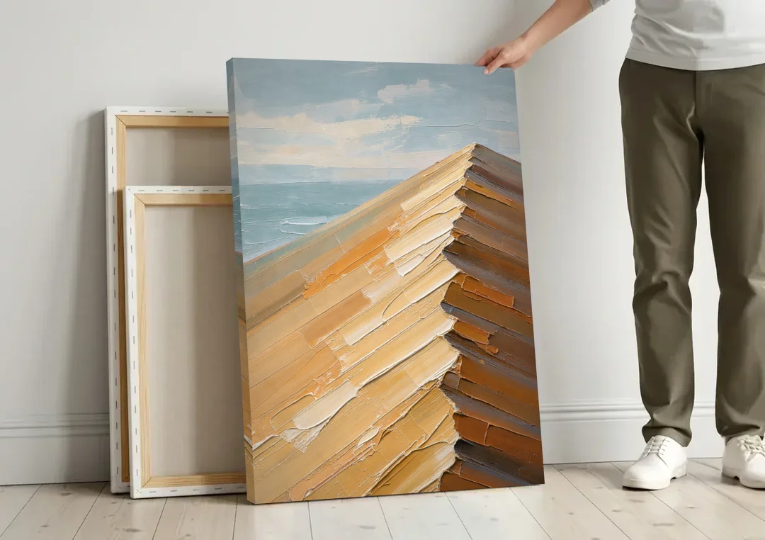 Textured Beige Abstract Dune Crest canvas wall art leaning against a wall next to blank canvases