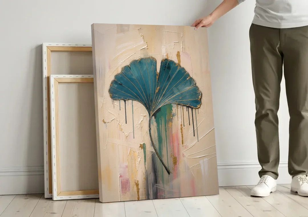 Textured Teal Ginkgo Leaf on Cream canvas wall art leaning against a wall next to blank canvases