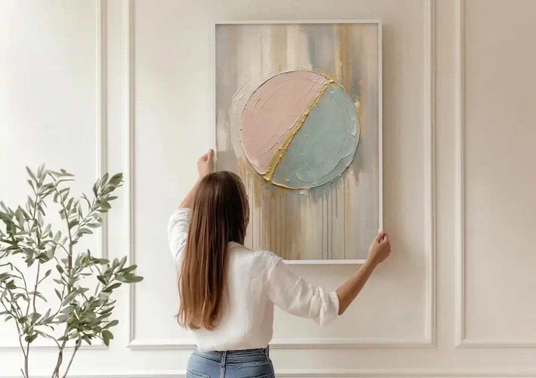 Textured Wall Art with Blush and Sea Glass Halves canvas wall art being hung on a paneled wall