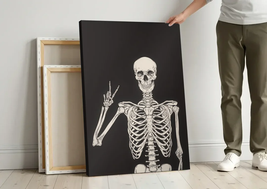 The Cool Halloween Skeleton canvas wall art leaning against a wall next to blank canvases