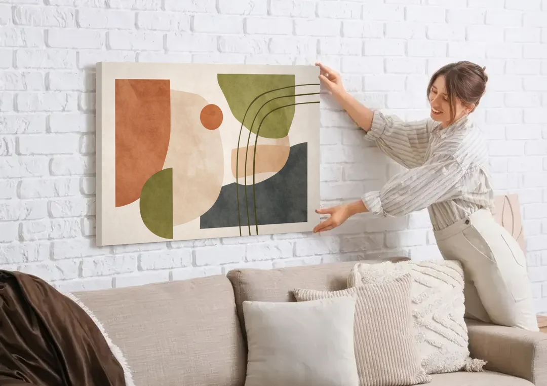 The Modern Composition canvas wall art being hung on a white brick wall above a sofa