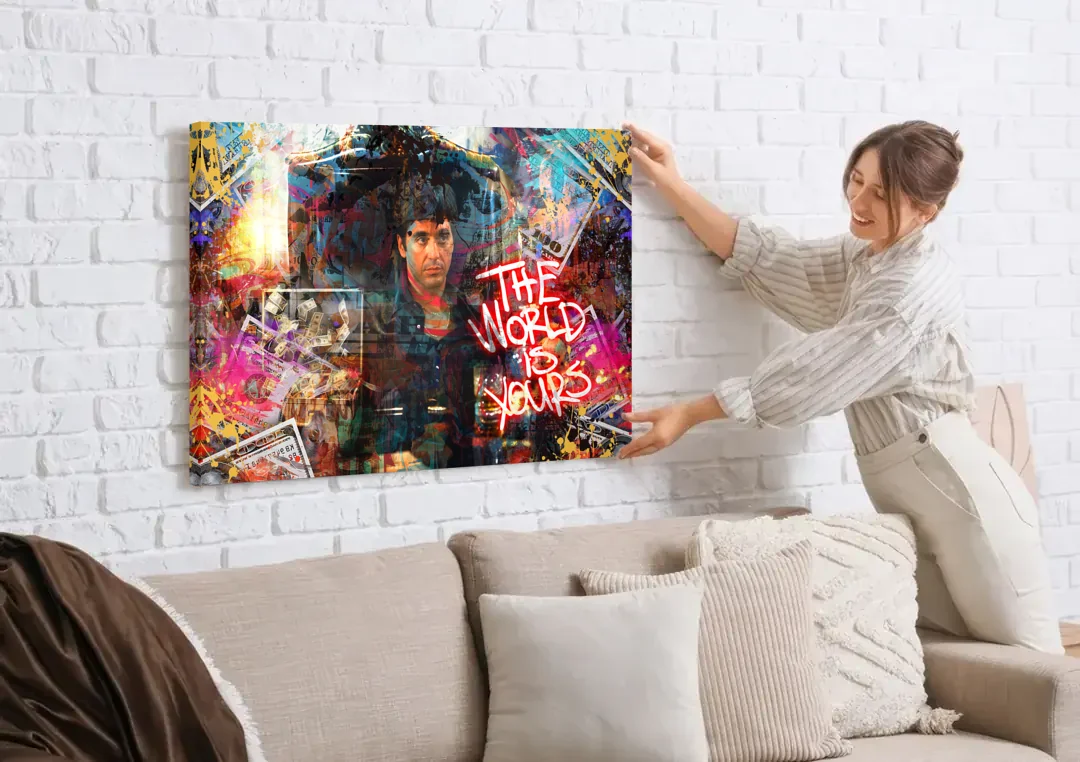 The World is Yours canvas wall art being hung on a white brick wall above a sofa