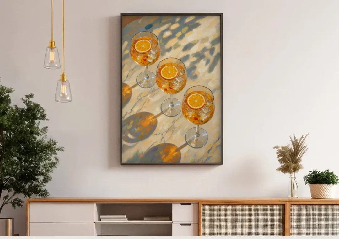 Three Orange Spritz Glasses in Dappled Sunlight canvas wall art above a wooden sideboard under pendant lights