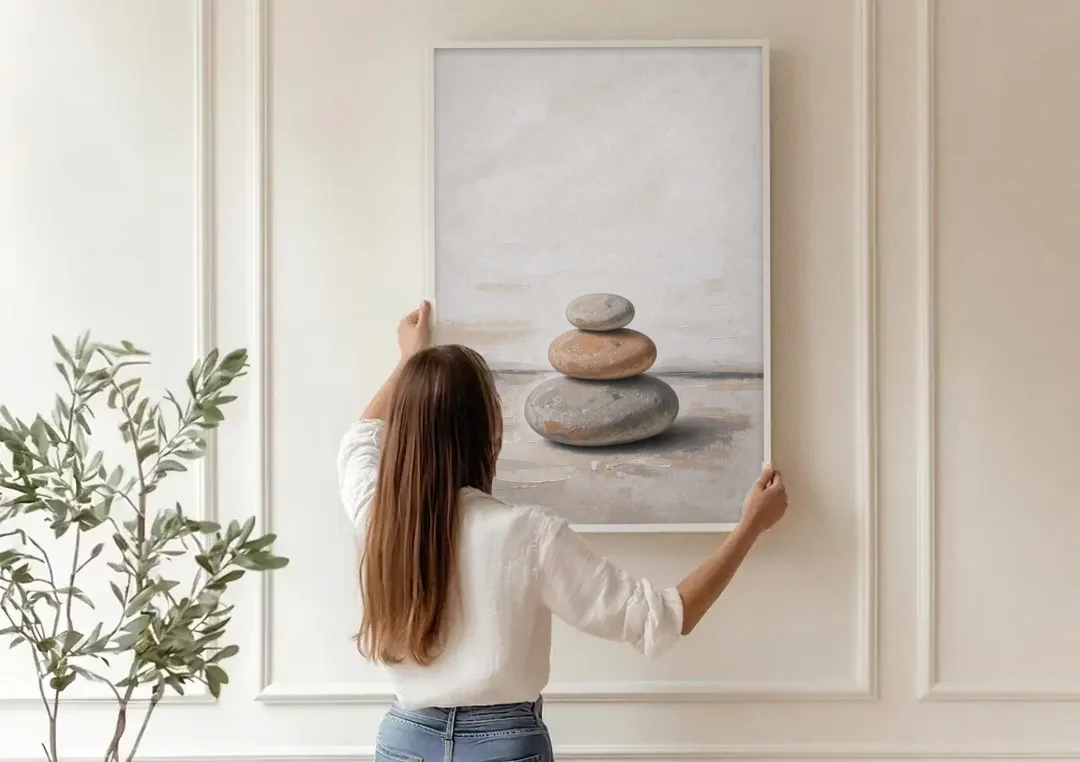 Three Stacked Stones on Pale Dusk Ground canvas wall art being hung on a paneled wall