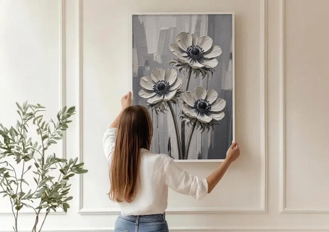 Three White Anemones with Black Centers canvas wall art being hung on a paneled wall