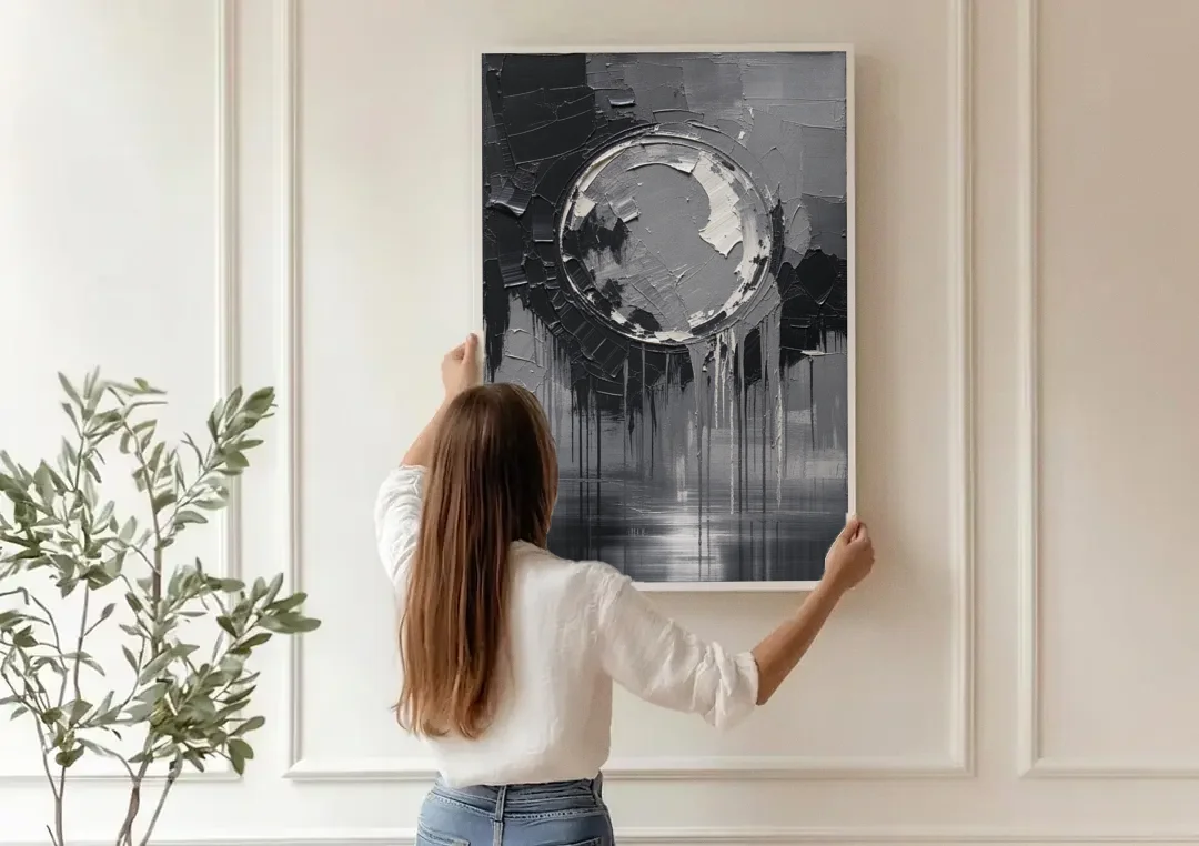 Torn Grey Circle Over Black Drips canvas wall art being hung on a paneled wall
