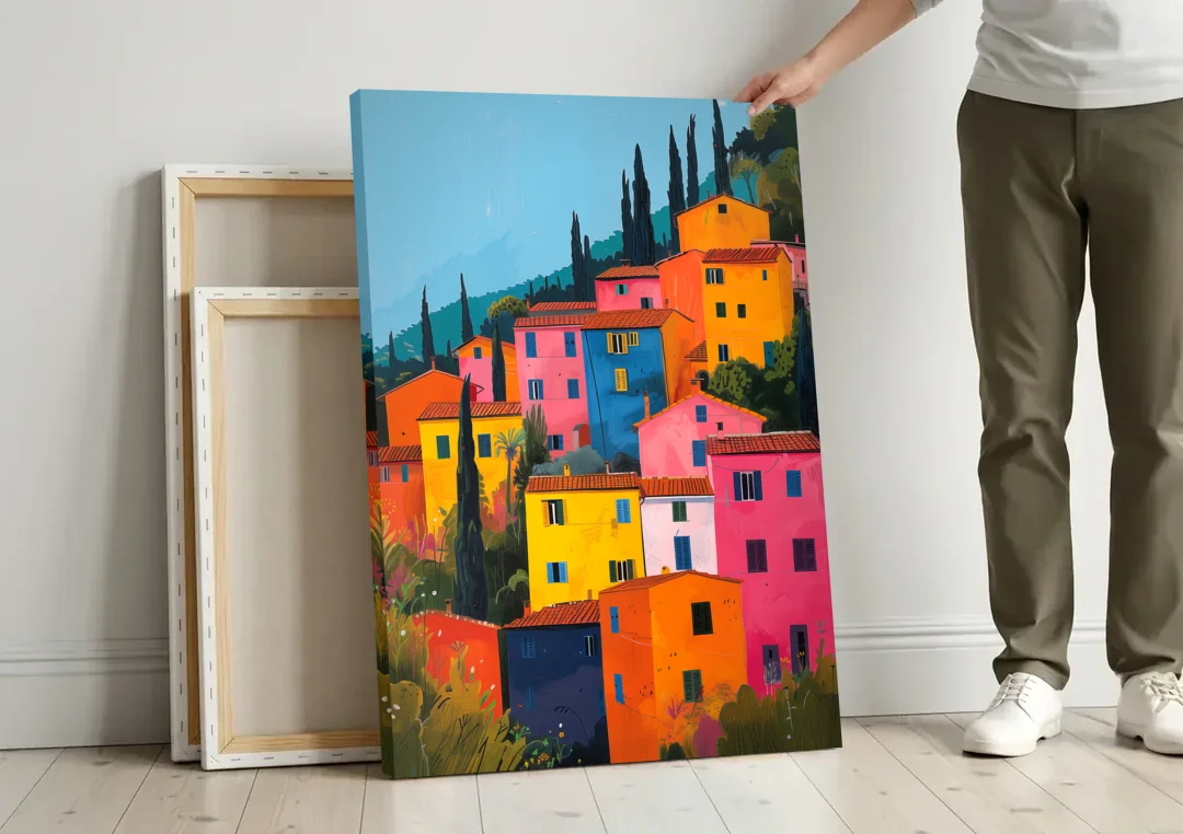 Tuscan Art of Colorful Hill Houses canvas wall art leaning against a wall next to blank canvases