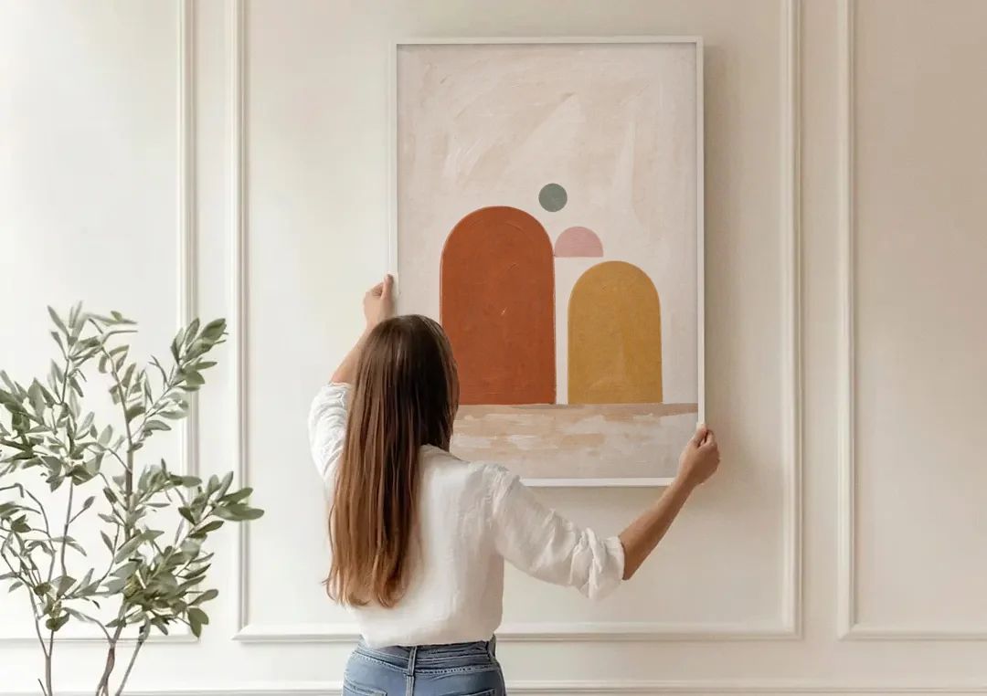 Two Uneven Arches with a Pink Half Sun canvas wall art being hung on a paneled wall