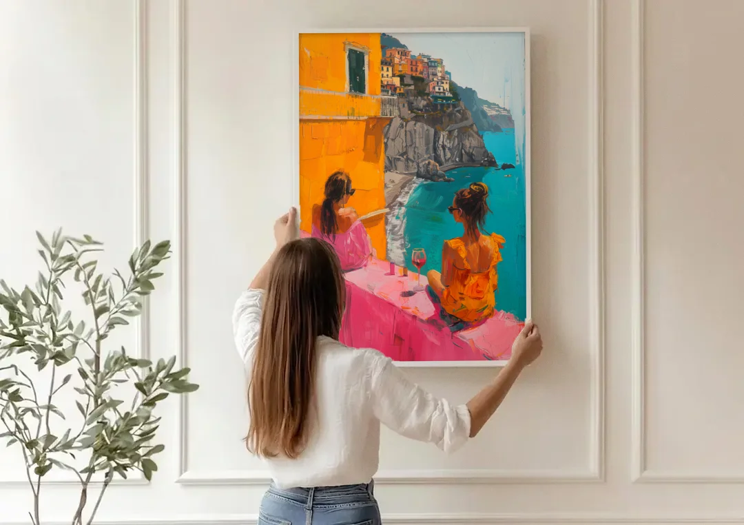 Two Women Painting by the Sea canvas wall art being hung on a paneled wall