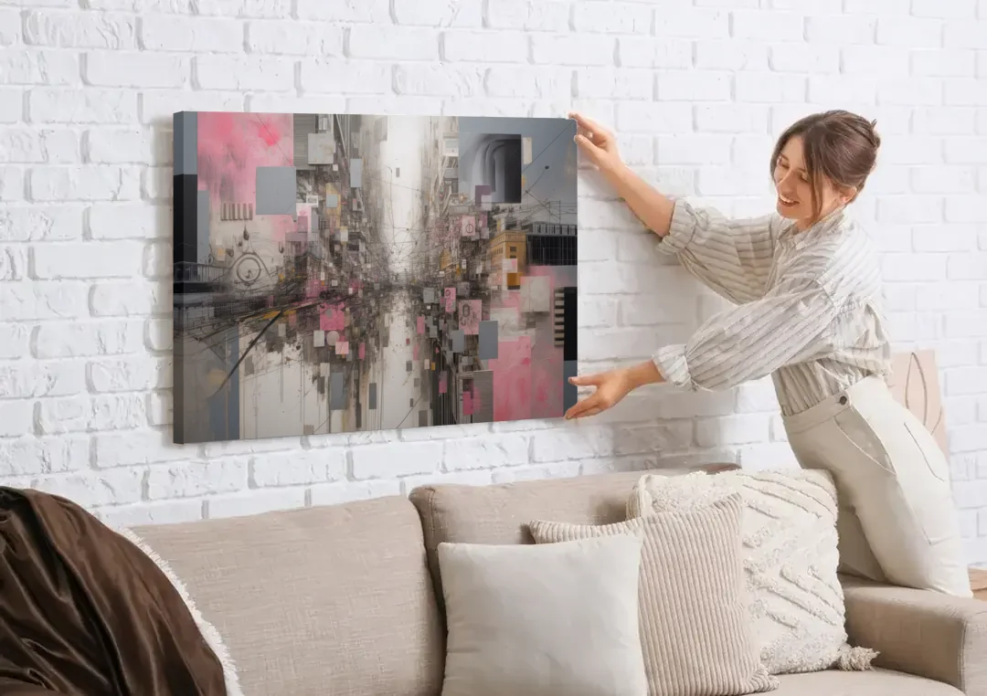 Urban Chaos Pink and Grey Abstract canvas wall art being hung on a white brick wall above a sofa