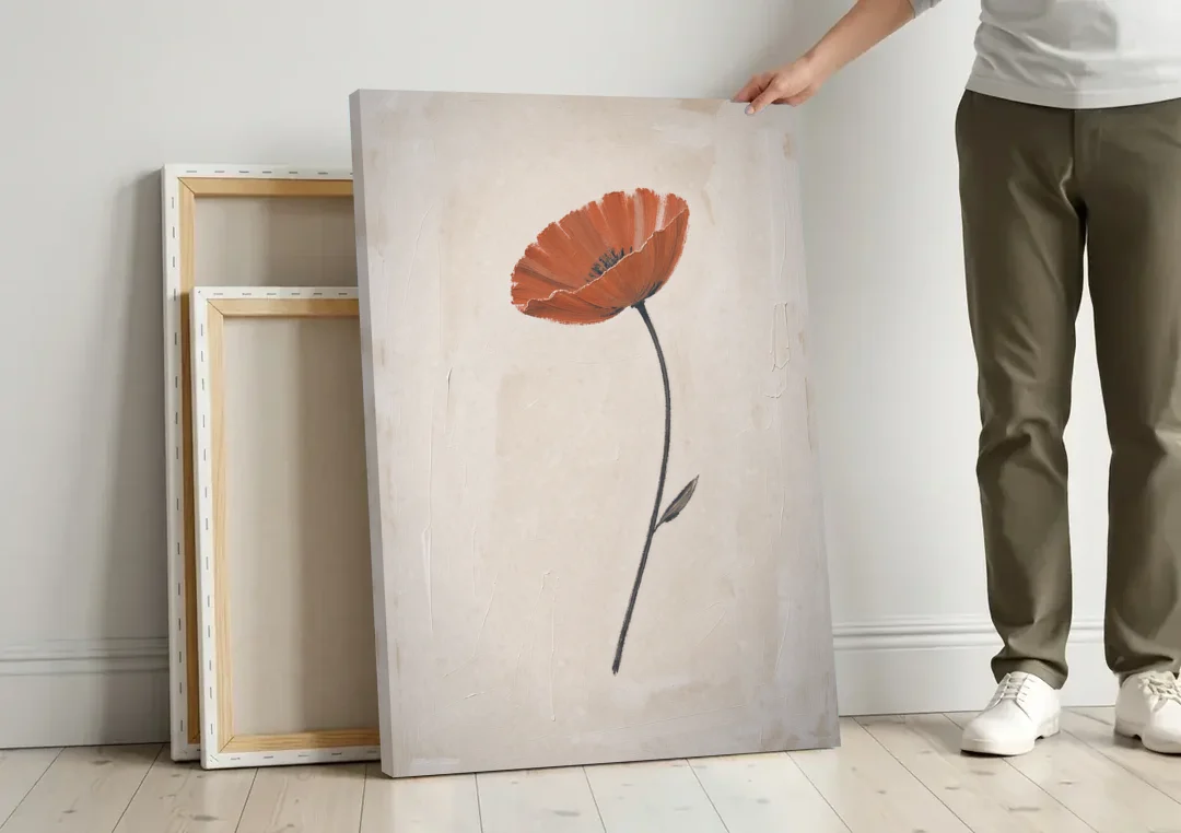 Vermilion Poppy on a Long Black Stem canvas wall art leaning against a wall next to blank canvases
