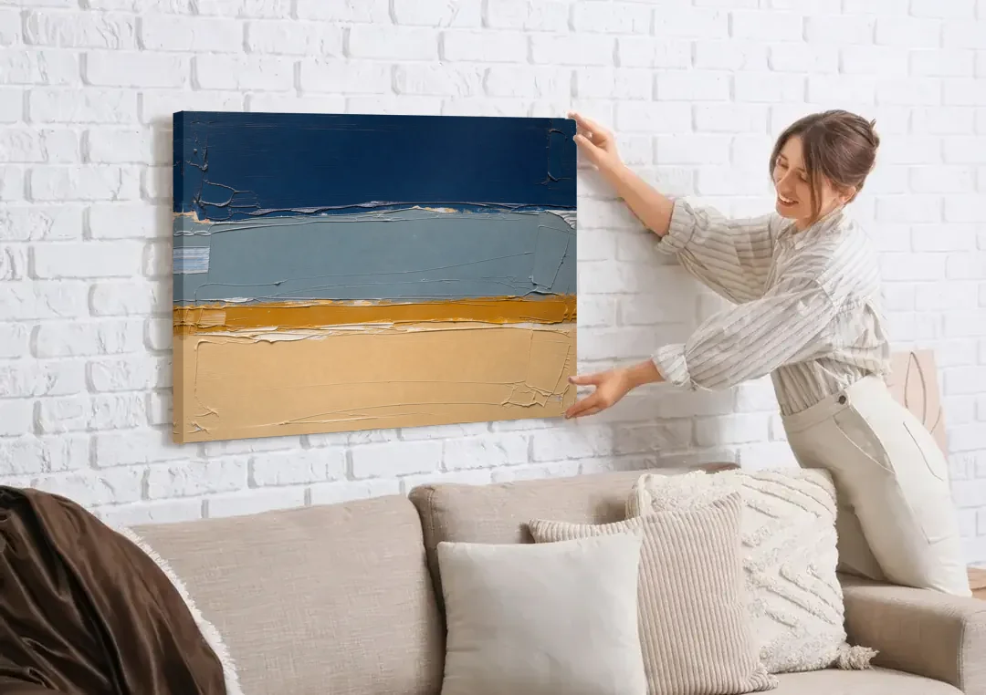 Wall Art for Office in Navy Slate and Sand canvas wall art being hung on a white brick wall above a sofa