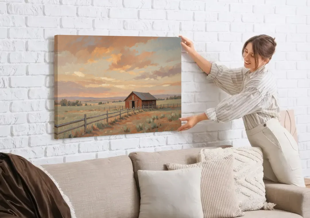 Western Landscape Painting with Lone Red Barn canvas wall art being hung on a white brick wall above a sofa