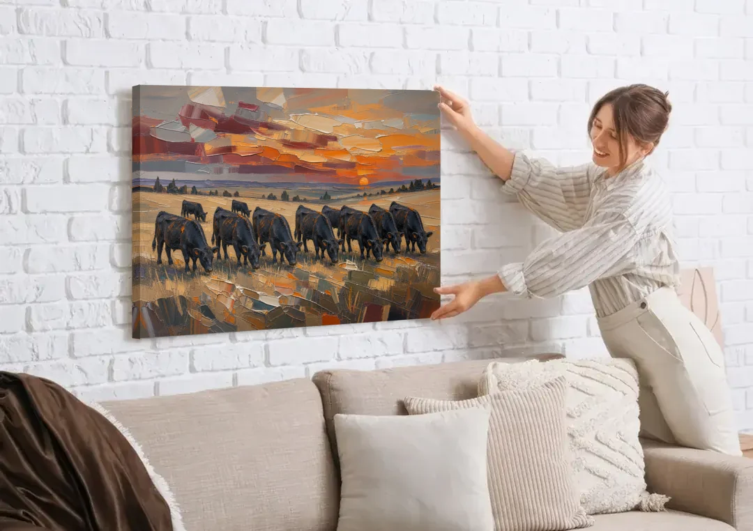 Western Wall Art of Angus Grazing at Sundown canvas wall art being hung on a white brick wall above a sofa