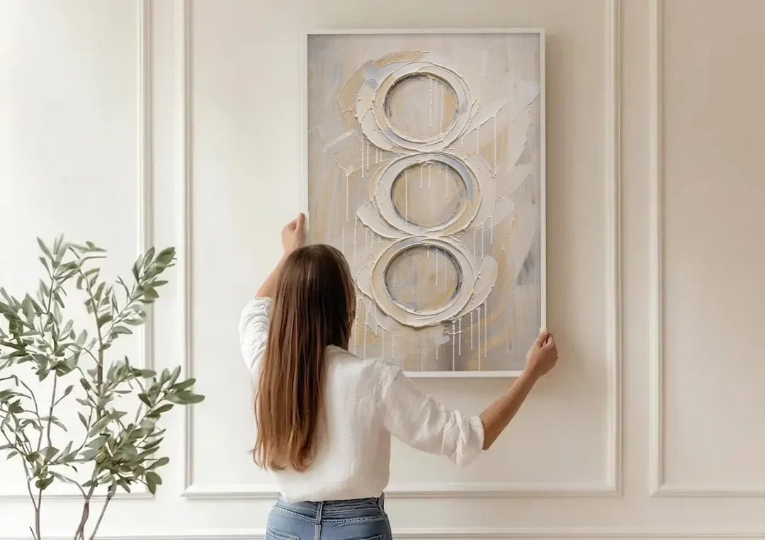 White Abstract Wall Art with Three Stacked Rings canvas wall art being hung on a paneled wall