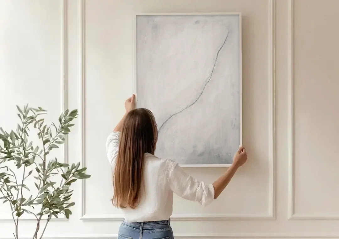 White Minimalist Wall Art with a Falling Charcoal Thread canvas wall art being hung on a paneled wall